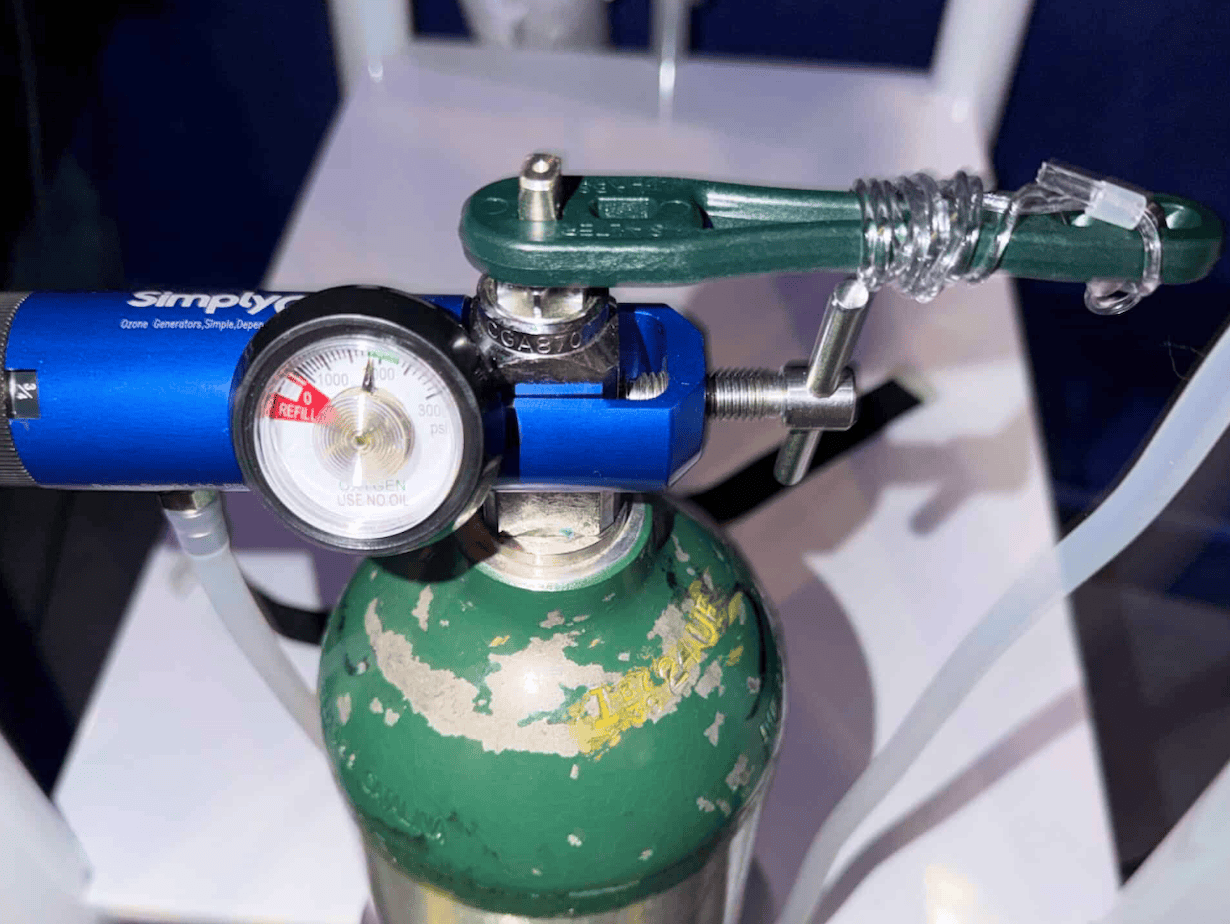 A green oxygen cylinder with a regulator and pressure gauge, used for medical oxygen delivery and respiratory support.